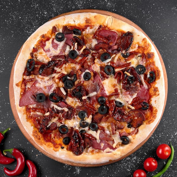 Italian pizza with pepperoni, sun-dried tomatoes, black olives, and cheese on a wooden board.